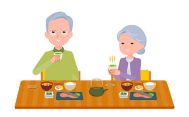 Yaşlı çift yemek sırasında sıcak yeşil meyve suyu içiyorlar.