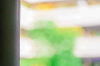 Yakınında beyaz bir bina bulunan bazı bitkilerin odaksız arkaplanı. Bulanık yapı alanı arkaplanı