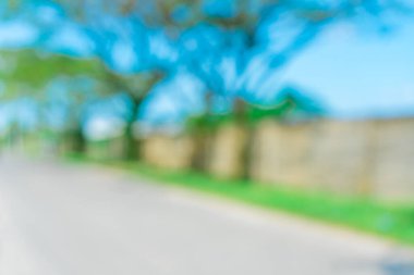 Yanı başında ağaçlar olan bir yolun soyut arkaplanı. Bulanık yol alanı arkaplanı