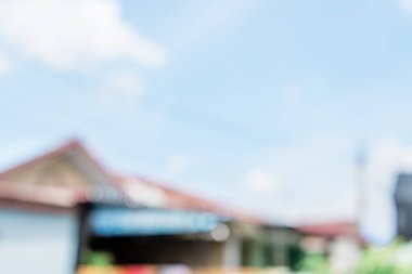 Mavi gökyüzünün, gökyüzünün altında birkaç bina bulunan soyut arkaplanı. Köy geçmişi bulanıklaştı