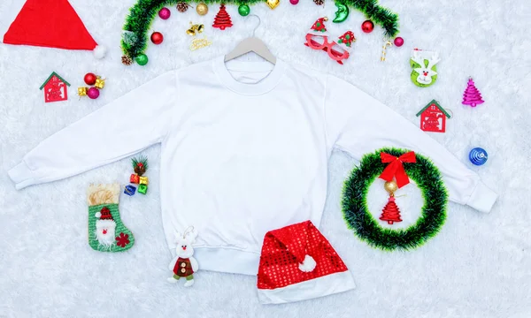 Noel temalı dekorasyonlu boş bir kazak modeli. Noel süsleri ve renkli hediye süslemeleriyle çevrili boş bir kazak. Doldurulacak boşluk. Noel süveteri modeli imajı