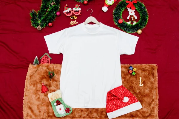 Noel temalı süslemeleri olan boş beyaz gömlek modeli. Noel süsleri ve renkli hediye süslemeleriyle çevrili boş bir gömlek. Doldurulacak boşluk. Noel gömleği modeli imajı