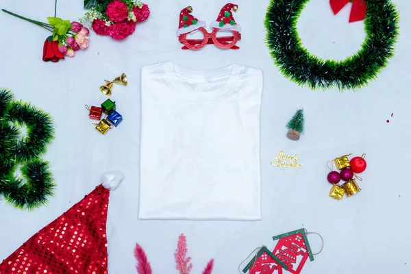 Noel süslemeleri ile katlanmış boş gömlek modeli. Noel süsleriyle çevrili boş katlanmış bir gömlek, renkli hediye süslemeleri. Doldurulacak boşluk. Noel katlanmış gömlek modeli