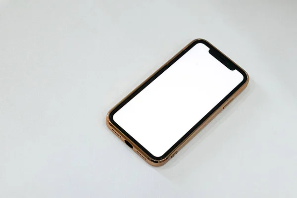 Gri bir zemine yerleştirilmiş bir akıllı telefon. Model için boş beyaz görüntü var.