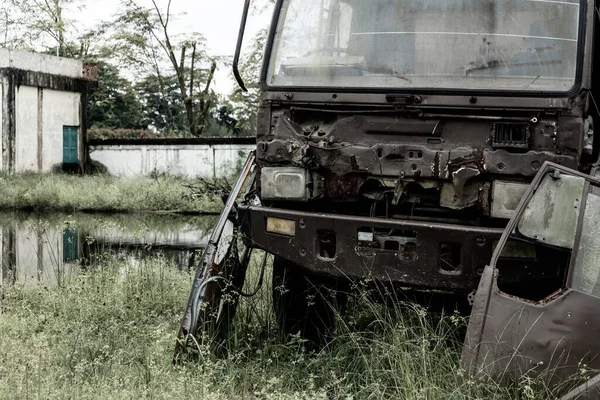 Broken old truck that has been badly damaged abandoned, in the middle of a park with scary vibes