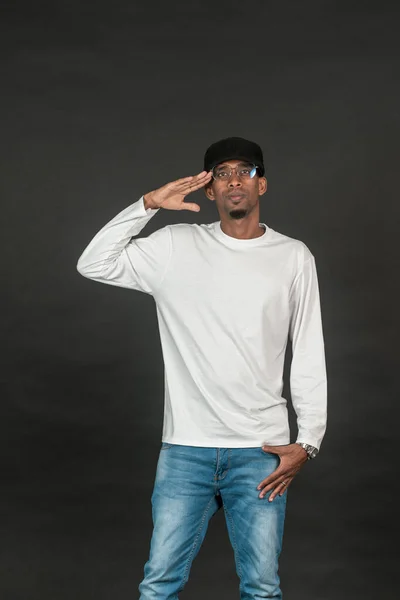 An african man with white blank shirt doing a salute pose on the black background