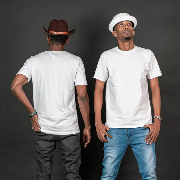 Two african man doing a simple pose with one facing back and the other facing front on the black background