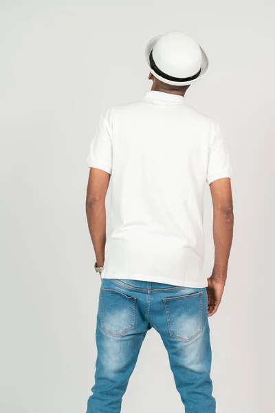 Back side of an african man with polo shirt doing a simple pose, with white background mockup image