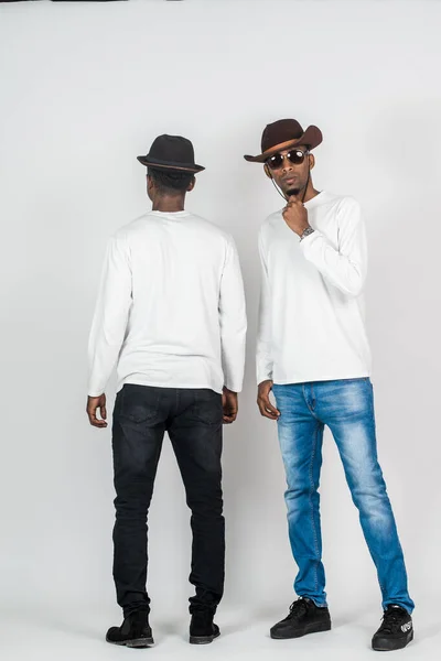 Two young african man doing a simple pose with one facing back and the other facing front on the white background