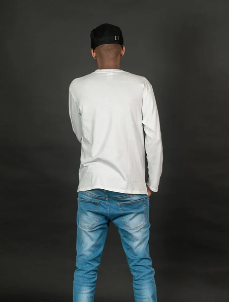 Back side image of an african man wearing white blank long sleeve shirt, doing a simple pose, on the black background