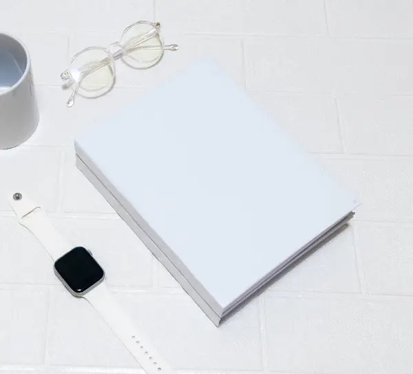 A couple of stacked white colored hardcover book laying out on the top of a white colored brick mat, hardcover mockup template image