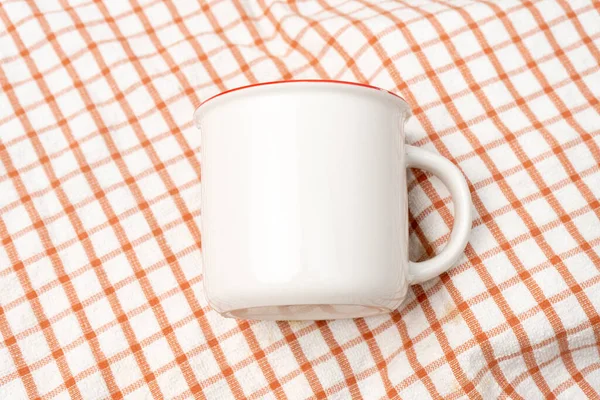 A white blank enamel mug on the top of a hand cloth with clean and simple looks, enamel mug mockup image