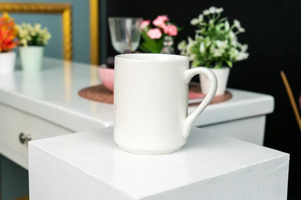 A white blank coffee mug on the top of a hand cloth with simple decorations arranged around it, coffee mug mockup image