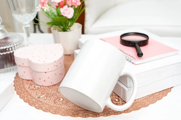 A white blank coffee mug laying out on a rounded mat with some decorations placed around it, coffee mug mockup image