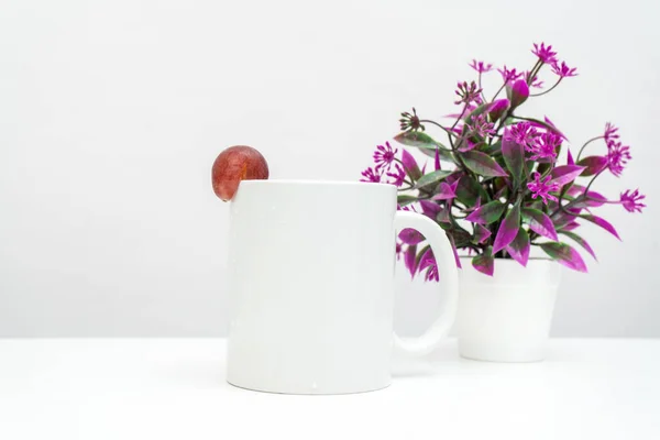 A white blank coffee mug with a grape decorated to the edge of the mug, minimalist fresh concept, coffee mug mockup image