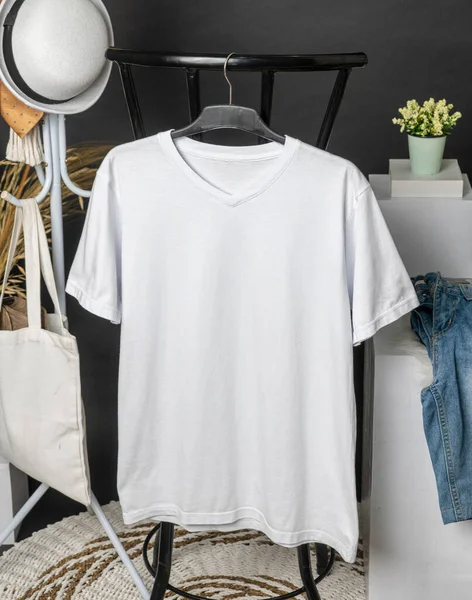A hanging v-neck shirt mockup featuring a clean and minimal design with subtle embellishments, adding an understated charm to the garment