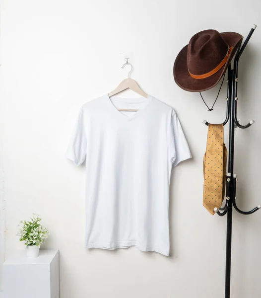 The v-neck shirt mockup presents a garment adorned with minimalist details, hung in a manner that accentuates its clean and stylish appeal