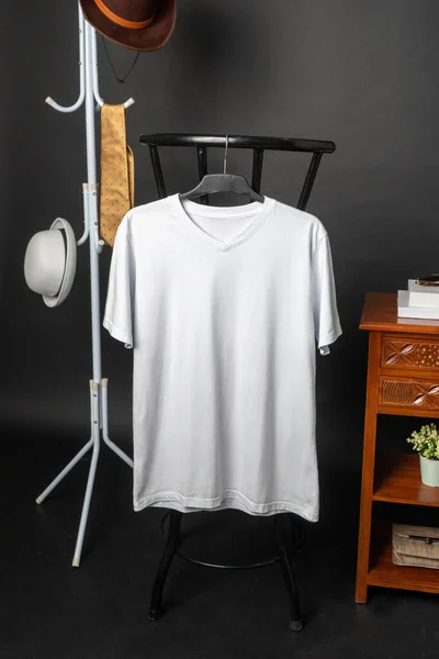 The v-neck shirt mockup highlights a garment with minimalistic details, hung in a way that showcases its refined and stylish appeal