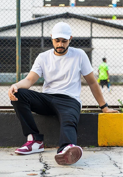 Beyaz gömlekli, şapkalı, bulanık tenis kortlu, beyaz şapkalı ve gömlekli genç adam.