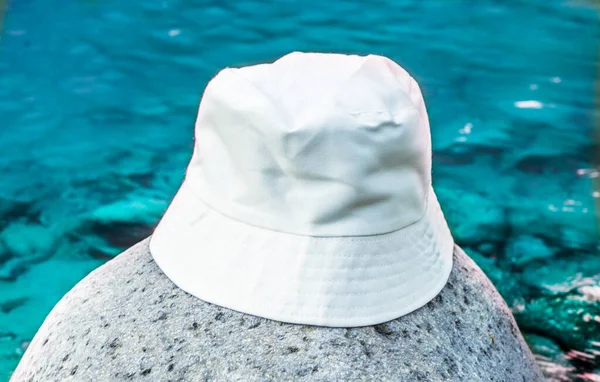 The white bucket hat in this photo adds a sense of elegance and sophistication to the tranquil setting near the river, white blank bucket hat mockup image