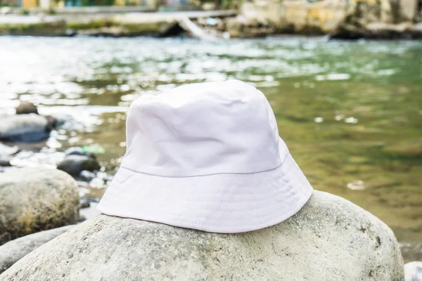 stock image With its clean and stylish design, this white bucket hat provides the perfect accessory for a day spent near the river, white blank bucket hat mockup image