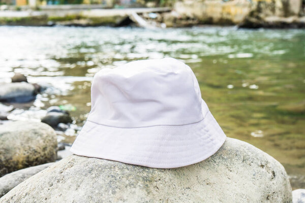 With its clean and stylish design, this white bucket hat provides the perfect accessory for a day spent near the river, white blank bucket hat mockup image