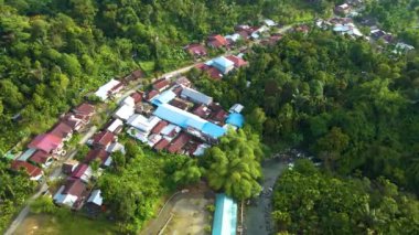 Etrafı ağaçlarla çevrili bir köyün hava görüntüleri dairesel hareketli bir dron tarafından çekildi.