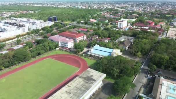 陸上競技場の一部とドローンによる降下運動で撮影された都市の空中映像 — ストック動画