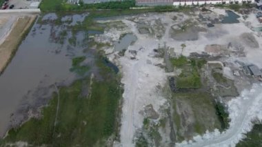 Önündeki bir depo ve şehir manzarasına giden toprak bir yolun hava görüntüleri, bir insansız hava aracı ile çekildi.