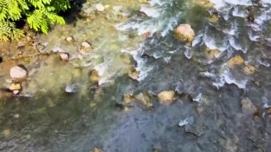 Su dalgalanmaları grubundan görüntüler, bir dron tarafından alçak irtifada çekilen kayalar arasında akmaya devam ediyor.