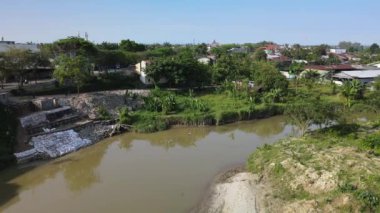 Yol kenarındaki bir nehir yolunun kahverengi renkli suyunun hava görüntüsü. Drone 'la çekilmiş.
