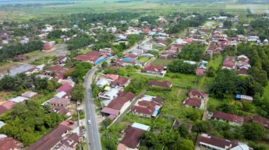 Üst tarafında mavi gökyüzü olan bir banliyöde insansız hava aracı ile çekilmiş hava görüntüleri.