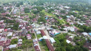 Bir insansız hava aracının kavisli hareketiyle bir yola odaklanmış bir banliyöde çekilmiş görüntüler.