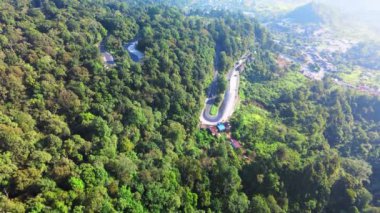 Bir tepenin gövdesindeki uzun kıvrımlı bir yolun insansız hava aracı ile çekilmiş hava görüntüleri.