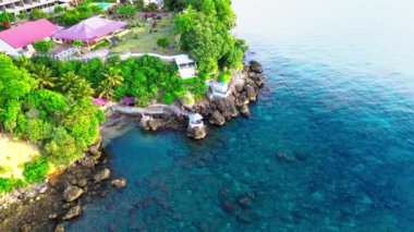 Küçük bir kalenin dairesel hareketini gösteren hava görüntüleri. Arkasında küçük bir köy olan bir kayanın üzerinde bir dron ile çekilmiş.