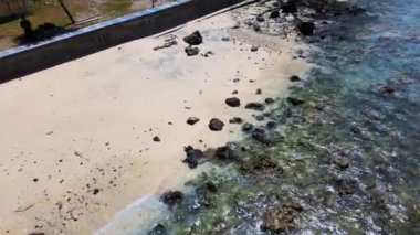 Bir sahile odaklanan ve daha sonra mavi renkli deniz suyuna ve ufka giden hava görüntüleri, bir dron ile çekildi.