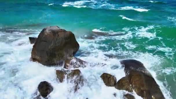 空中拍摄的镜头集中在一组岩石上 这些岩石不断受到海水波涛的冲击 这些岩石是用无人驾驶飞机拍摄的 — 图库视频影像