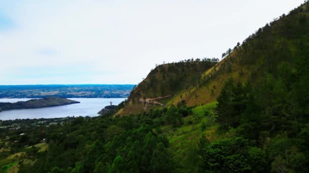 背景にSerene Lake Viewがある丘の中腹の村の魅力的な美しさを明らかにする空中映像の魅力 — ストック動画