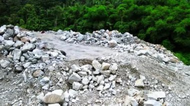 Hava görüntüleri, dağlık arazide devam eden yol yapım alanını ve etrafa dağılmış kayaları gözler önüne serdi.