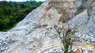 Huşu uyandıran hava görüntüleri, dağlık arazide bulunan yol yapım alanını gözler önüne serdi. Arazi dağınık kayalarla süslenmişti. Bu da zorlu bir mühendislik sınavı sunuyordu.