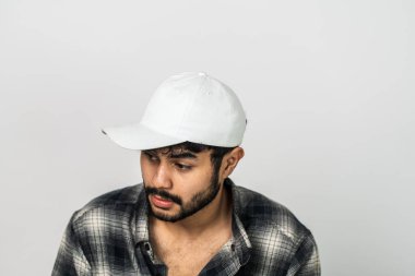 Model, beyaz şapkalı bir adamı sergiliyor. Basit bir poz vererek çok yönlülüğünü gösteriyor.