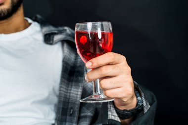 Profesyonel olarak sunulan resimde, elinde kırmızı renkli bir içecek olan ve pazarlama görselleri için ideal bir adam resmediliyor.