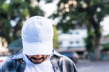 Çabasız bir şekilde şık, bir model modeli genç bir adam ve beyaz bir şapkayla moda ruhunu yakalıyor.