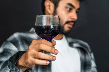 Çabasız bir şekilde stil kazanır. Genç bir adam şarabını gösterirken bir anlık zevk yakalar.