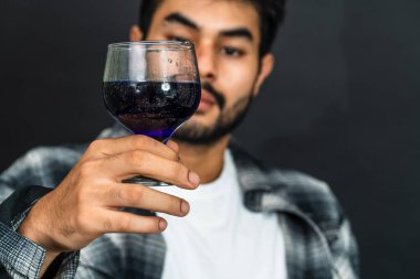 Genç bir adamın içkisini bu çekici görüntüde sunarken şarap tatma zevkini kucaklayın.