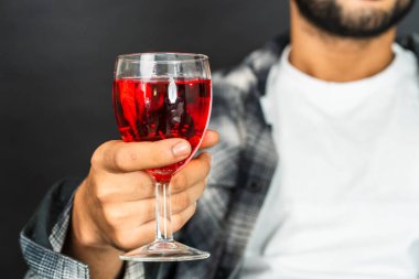 Şarap kültürünün sıcaklığını kucakla genç bir adam gururla içkisini bu büyüleyici sahnede sergiliyor.