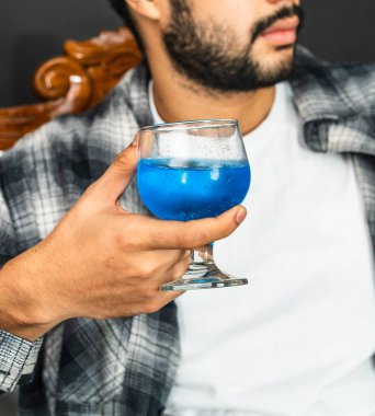 Şarap kültürünün sıcaklığını kucakla genç bir adam gururla içkisini bu büyüleyici sahnede sergiliyor.