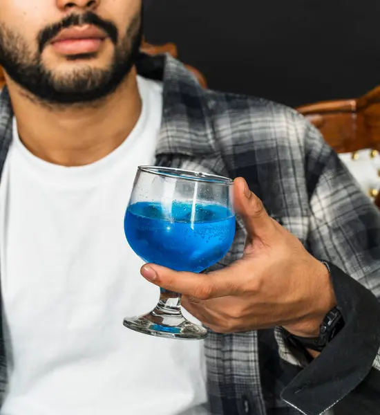 Şarabın cazibesini kucakla genç bir adam bu büyüleyici sahnede içkisini kendinden emin bir şekilde gösteriyor.