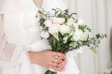 Bride's bouquet with white flowers. The bride holds a beautiful bouquet in her hands.
