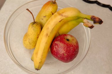 Muzlar ve elmalar mutfakta cam kasede.